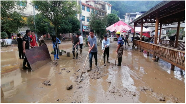 干部群众在清理道路上的淤泥。