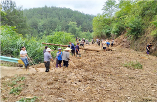 干部群众在清理道路上塌方的泥土。