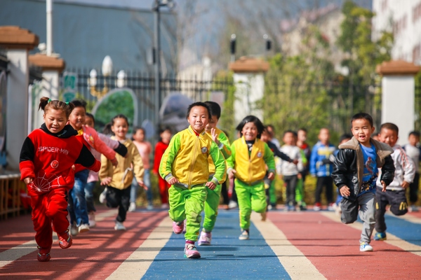 七星关区第三幼儿园的小朋友在跑道上赛跑。