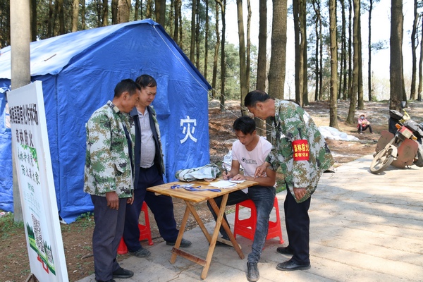 护林员指导进山人员作登记。