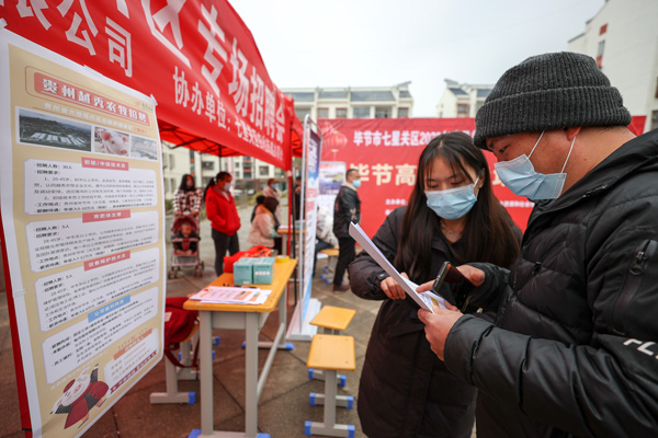 在七星关区归化街道生态移民安置点招聘会现场 企业工作人员正在向搬迁群众介绍薪资待遇。张怡婷摄