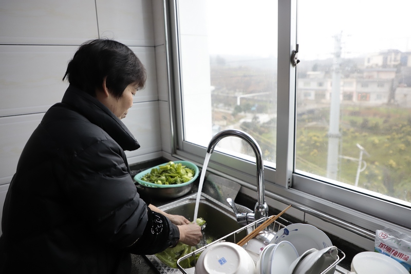 西洛街道群立社区居民钱帮红正使用自来水洗菜。.jpg