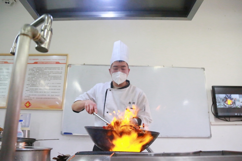 毕节职业技术学院“粤菜师傅”培训班的学生在练习炒菜。