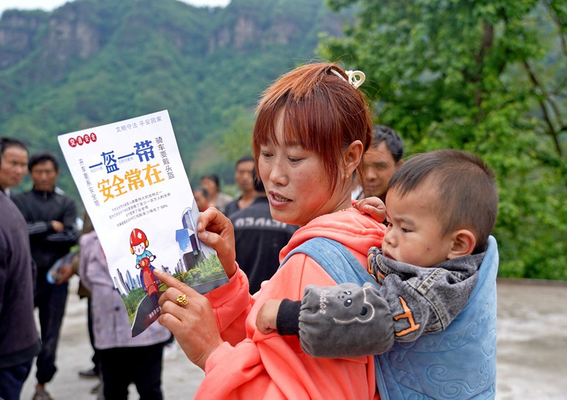 2023年5月9日，贵州省纳雍县水东镇簸落村，家长在给小朋友讲解交通安全知识。（杨英 摄）