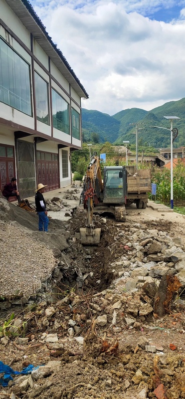 挖掘机正在社区内挖渠。