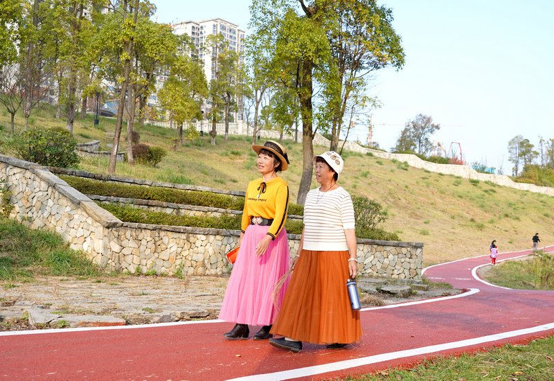 2023年11月17日，贵州省纳雍县白水河湿地公园，市民在刚刚铺装的彩色沥青健身道上散步。 杨英摄