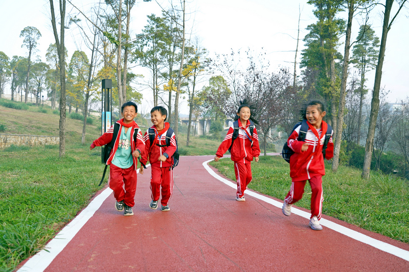 2023年11月17日，贵州省纳雍县白水河湿地公园，同学们在刚刚铺装的彩色沥青健身道上奔跑。 杨英摄