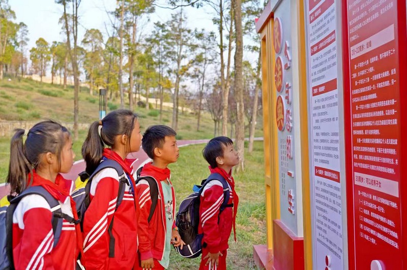贵州省纳雍县放学的学生正在看白水河公园里法治文化宣传标牌“法文化”   杨英摄.jpg