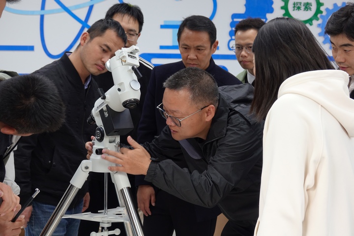 民进云南省委会常委、中国科学院云南天文台研究员刘亮，正在和学校的老师们一起组装天文望远镜。