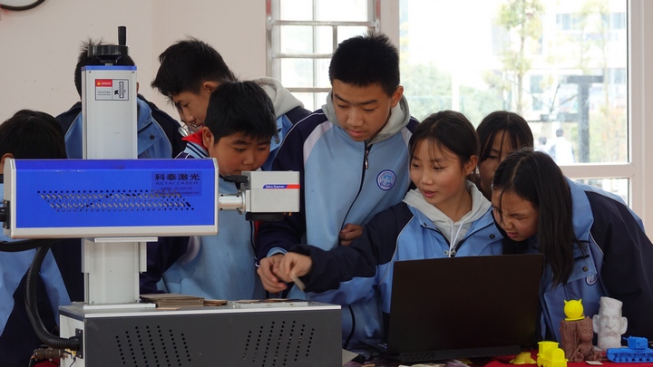 金沙教育研究附属学校的学生在研究科技创新机器。