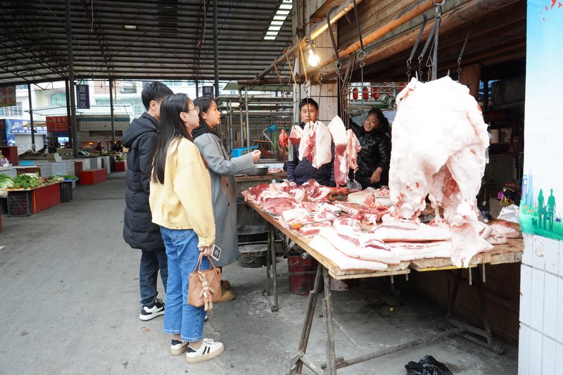 金沙县市场监督管理局工作人员正在查看猪肉摊是否更换灯具.jpg