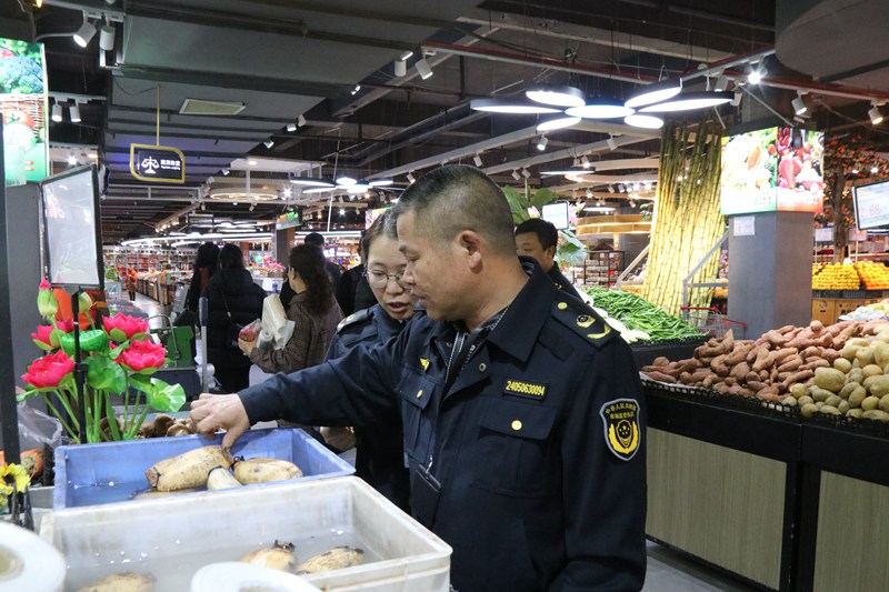 2023年12月18日，纳雍县市场监管局工作人员在超市察看蔬菜类颜色是否正常。杨其飞 摄