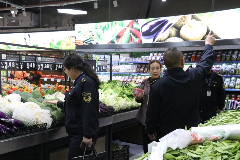 2023年12月18日，纳雍县市场监管局工作人员在超市察看蔬菜类产品禁用生鲜灯情况。杨其飞 摄 (2)
