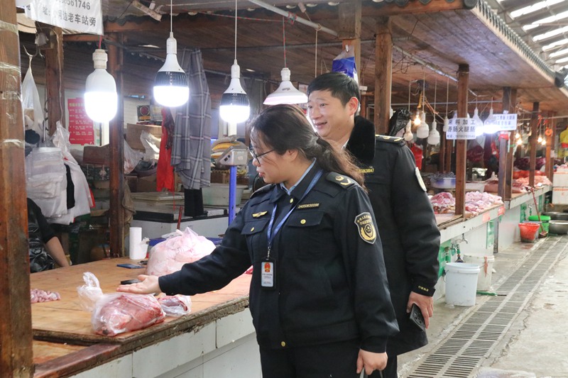 2023年12月18日，纳雍县市场监管局工作人员在农贸市场用手试探是否禁用生鲜灯。杨其飞 摄