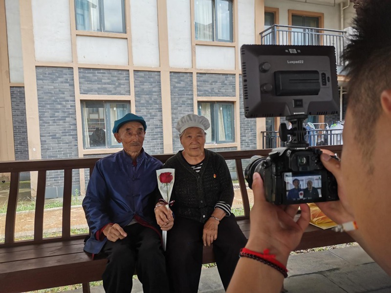 社工为老年夫妇拍摄合影。