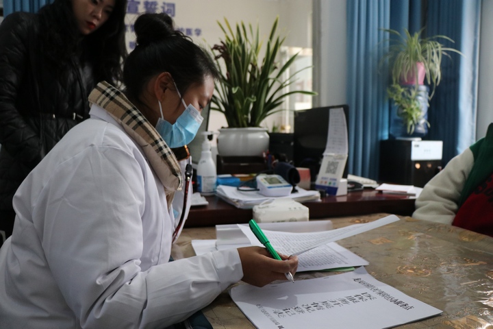 撒拉溪镇龙凤村村级医保经办服务点 ，医生在核对报销情况。