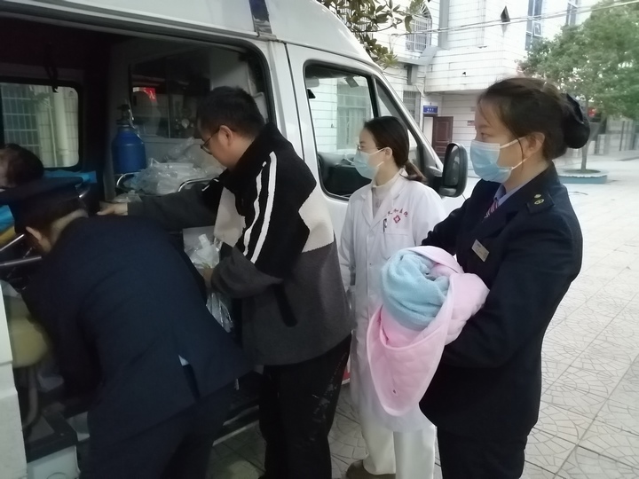产妇一家顺利登上前来接送的救护车。尚欣宇摄