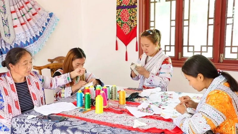 杨文丽（右二）正在和绣娘们一起刺绣。