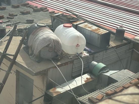 4月中旬，朝阳小区一房顶的两个醇基燃料桶暴露在阳光下。人民网记者 金慧慧摄