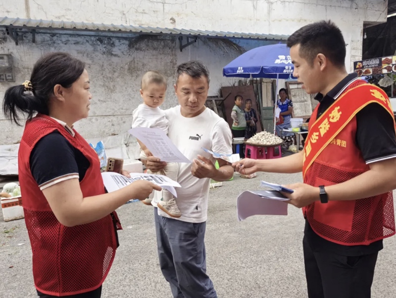 2重庆市秀山宣传现场，工作人员向民众分发传单